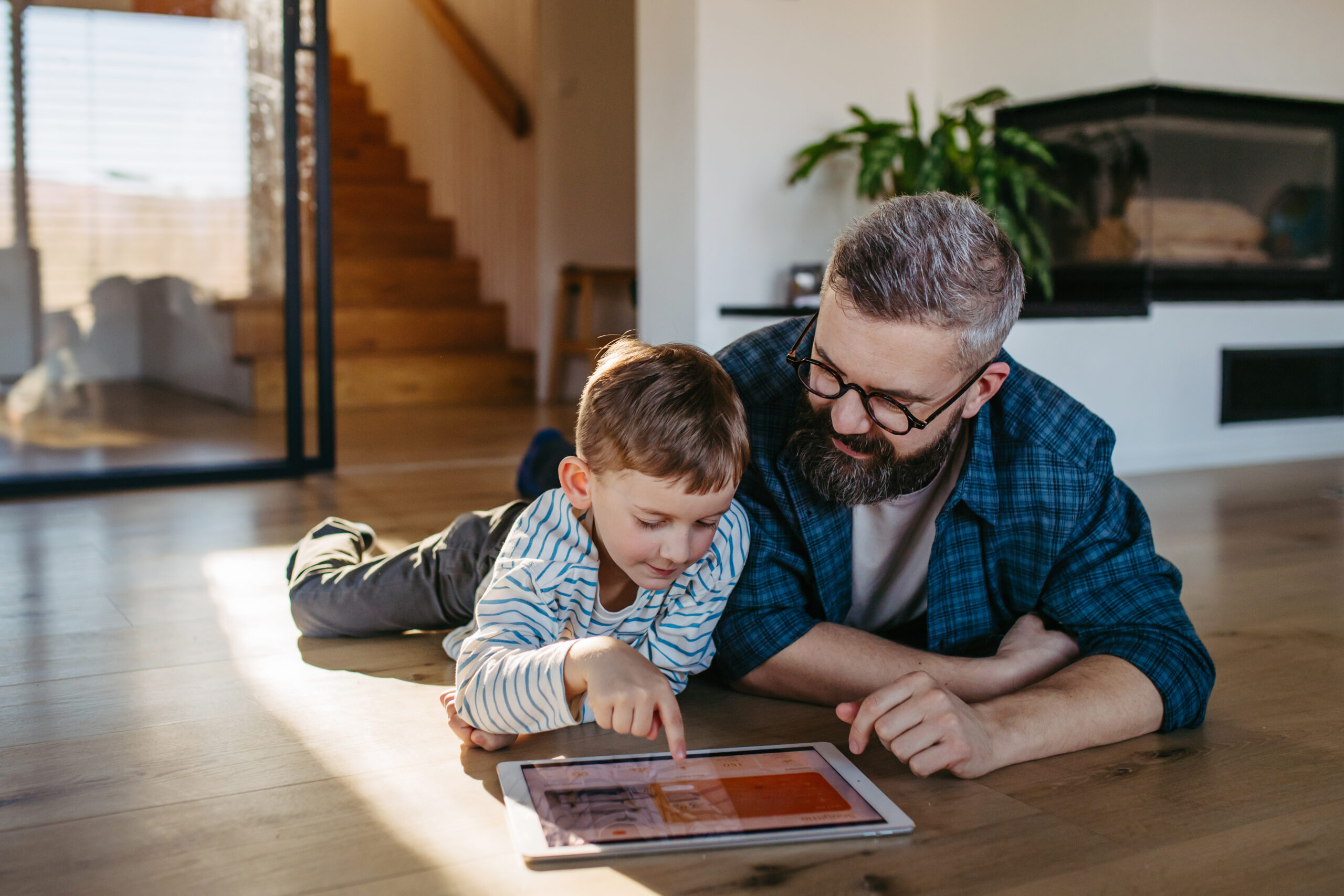 Image of dad and young son on tablet device enjoying fast Internet service
